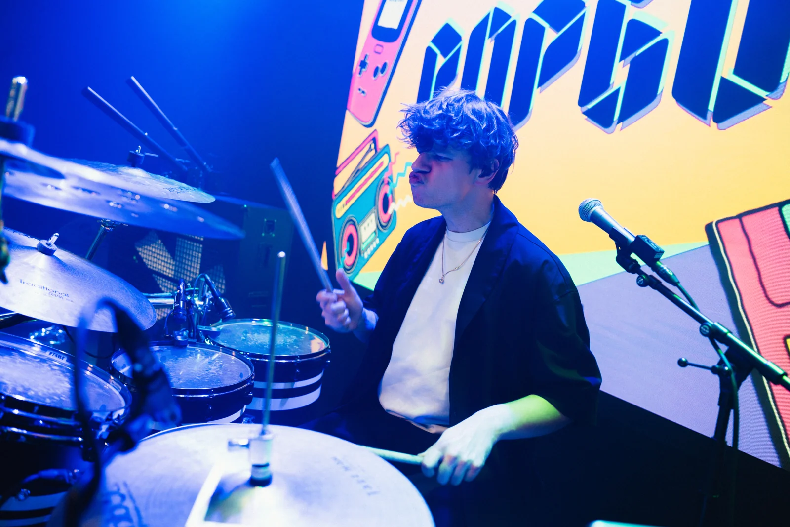 Sven achter de drums in blauw podiumlicht