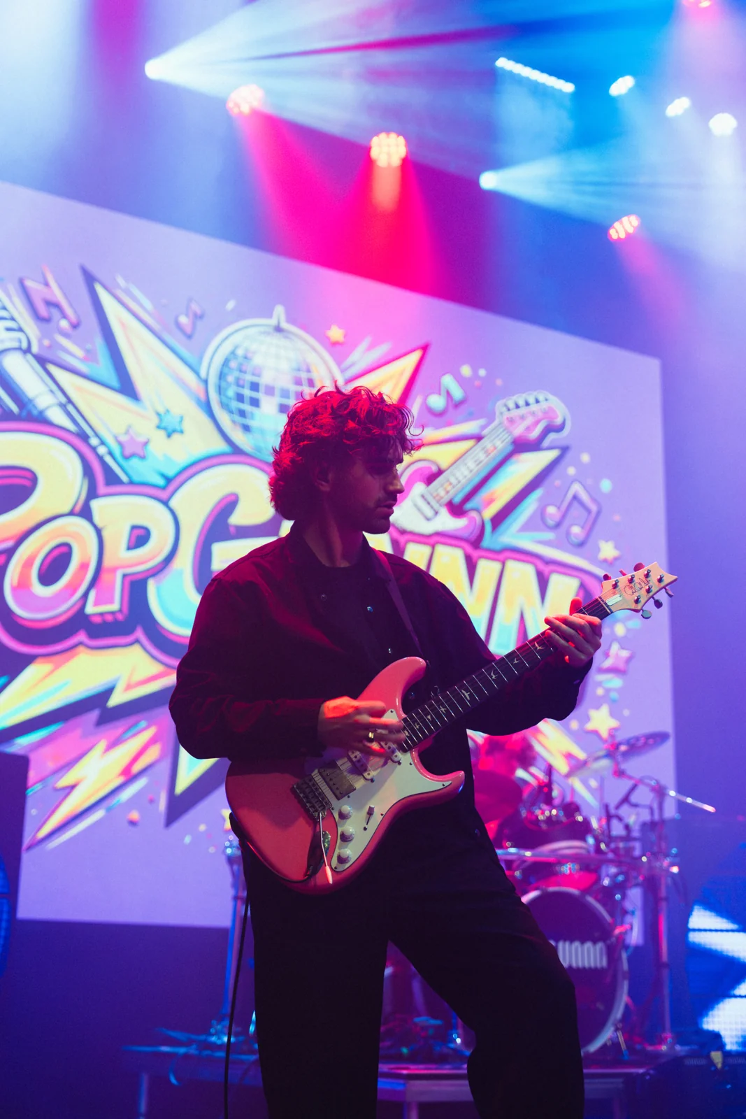 Mart op gitaar, voor het POPGUNNN-podiumdecor